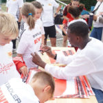 Unions Stürmer Ilyas Ansah gibt den Kids des Sommercamps Autogramme.