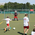 Ein Mädchen schießt auf das Tor von Ritter Keule, dem Maskottchen vom 1. FC Union Berlin.