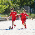 Jungs beim Zweikampf im Sandkasten der Beach-Soccer-Anlage.