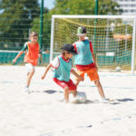 Kinder des Berliner TSC Sommercamps spielen Beach Soccer.
